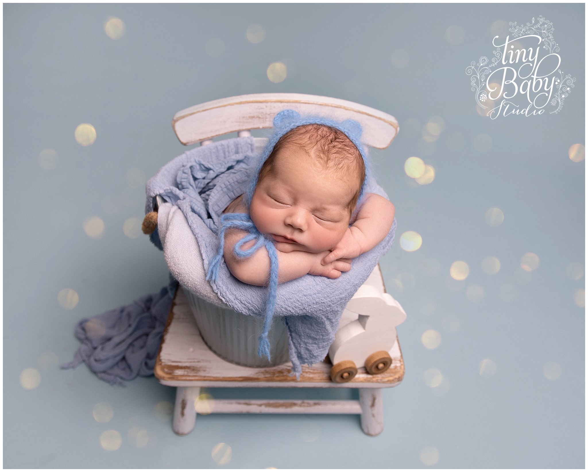 Newborn baby during photoshoot in comfortable props and wraps