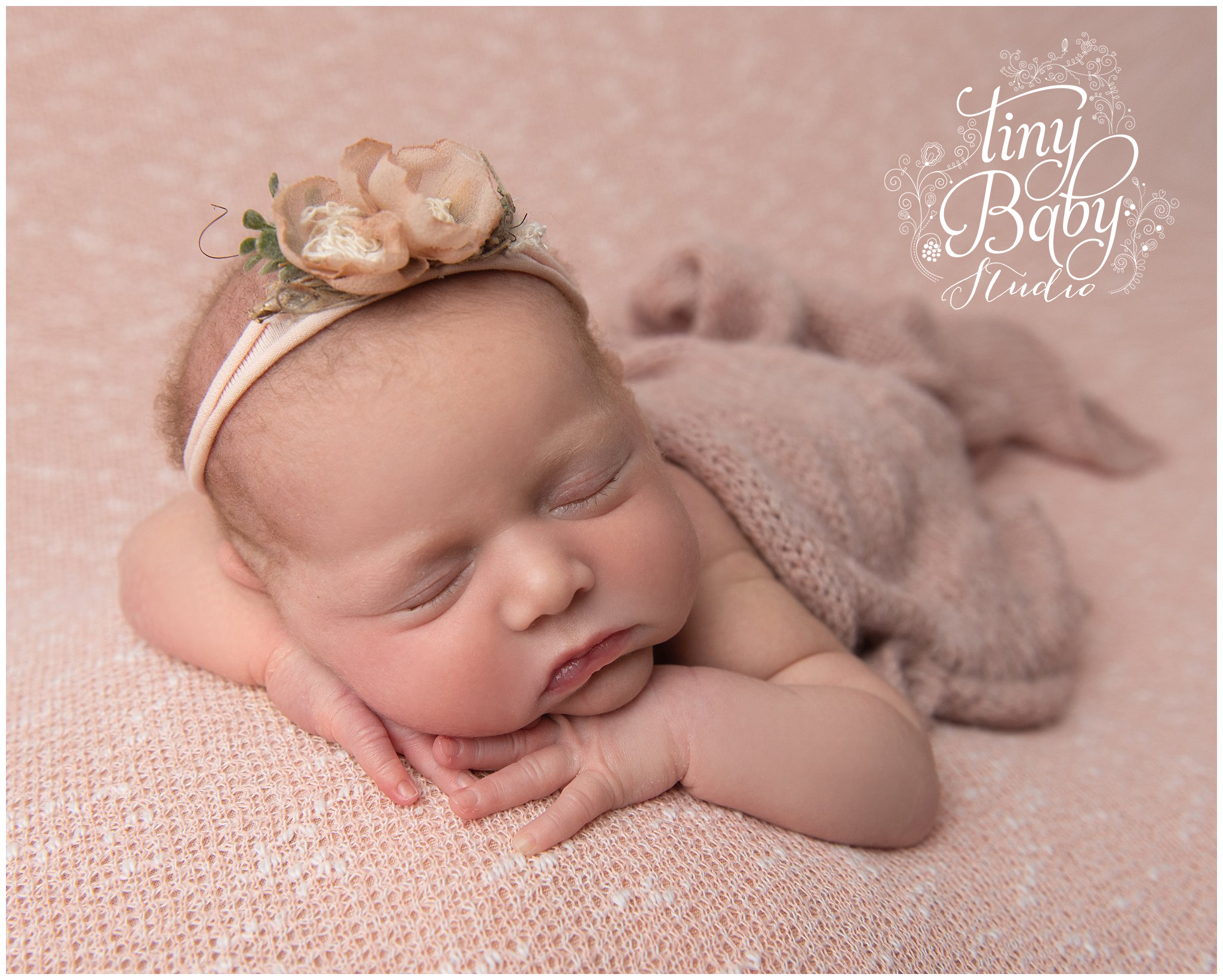 Newborn baby during photoshoot in comfortable props and wraps